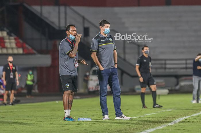 Pelatih timnas Timor Leste, Fabio Maciel (kanan), sedang memantau para pemainnya Penyerang timnas Indonesia, Hanis Sagara Putra (kiri) , sedang berebut bola dengan bek timnas Timor Leste, Filomeno Junior Da Costa (kanan), di Stadion Kapten I Wayan Dipta, Gianyar, Bali, 27 Januari 2022.