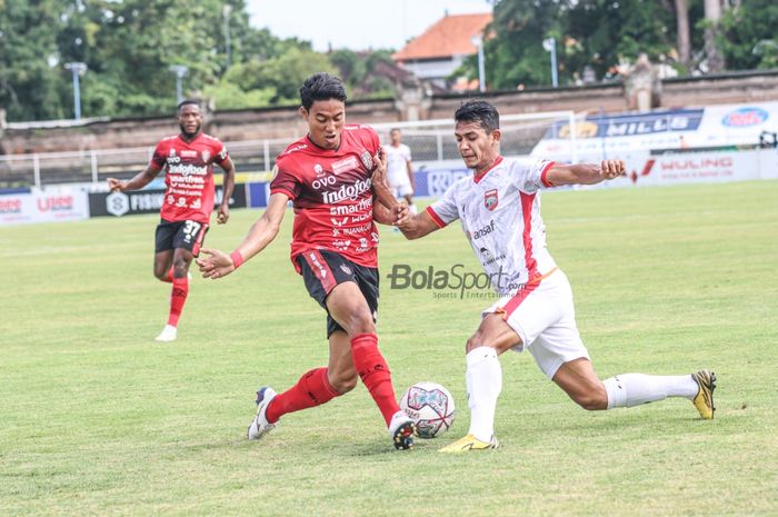 Bek Bali United, I Made Andhika Wijaya (kiri), sedang berebut bola dengan pemain Borneo FC, Leo Guntara (kanan), dalam laga pekan ke-21 Liga 1 2021 di Stadion Gelora Ngurah Rai, Bali, 29 Januari 2022.