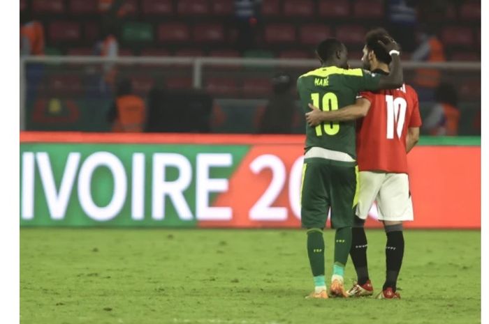 Momen Sadio Mane (kiri) berbicara dengan Mohamed Salah usai final Piala Afrika 2021. 