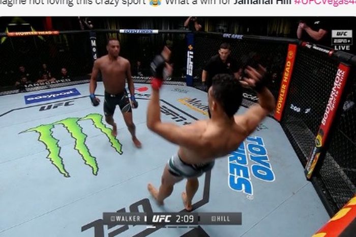 Momen Johnny Walker mengangkat kedua tangannya usai terkena bogem ganas Jamahal Hill pada UFC Vegas 48 (20/2/2022) WIB.