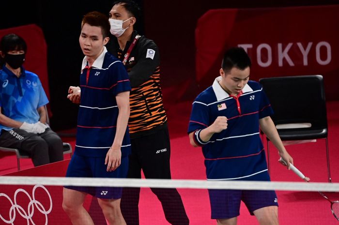 Pasangan ganda putra Malaysia, Soh Wooi Yik (kiri) dan Aaron Chia, bersama pelatih,  Flandy Limpele, bereaksi setelah kemenangan atas Marcus Fernaldi Gideon/Kevin Sanjaya Sukamuljo (Indonesia) pada perempat final Olimpiade Tokyo 2020 di Musashino Forest Sports Plaza, Tokyo, Jepang, 29 Juli 2021.