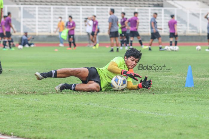 Kiper timnas U-23 Indonesia, Muhammad Adi Satryo, sedang menangkap bola dalam latihannya di Stadion Madya, Senayan, Jakarta, 12 April 2022.