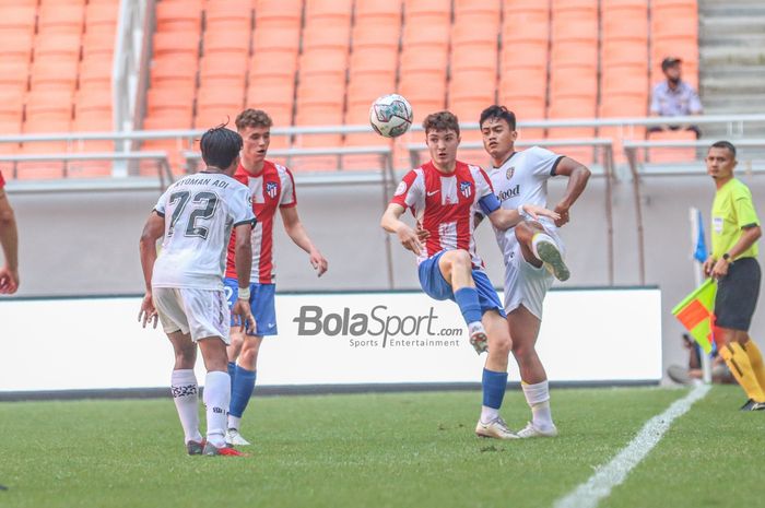 Striker Atletico Madrid U-18, Adrian Gallego Diaz (kiri), sedang berduel dengan pemain Bali United U-18 bernama I Gede Agus Mahendra (kanan) di Jakarta Internasional Stadium, Jakarta Utara, 13 April 2022.