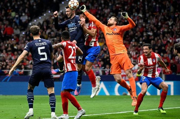 Kiper Atletico Madrid, Jan Oblak, meninju bola dalam duel perebutan dengan pemain Manchester City dalam duel Liga Champions di Wanda Metropolitano, Madrid (13/4/2022).