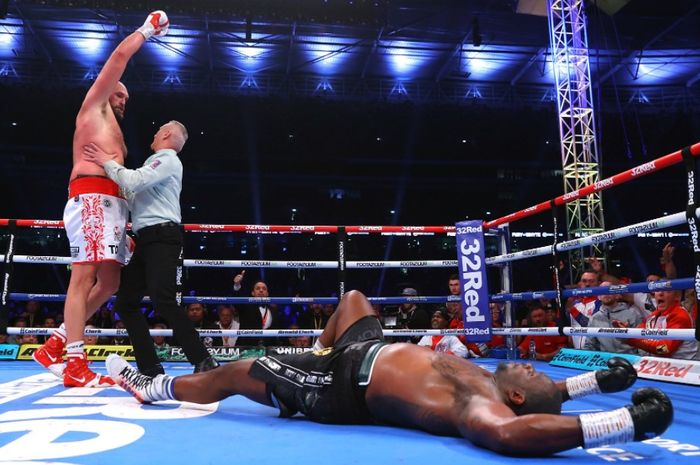 Tyson Fury (kiri) ketika menganvaskan Dillian Whyte (kanan/bawah) pada duel mereka yang berlangsung di Stadion Wembley, London, Inggris, Sabtu (24/4/2022).