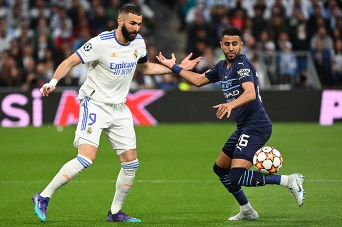 Striker Real Madrid, Karim Benzema, berduel dengan penyerang Manchester City, Riyad Mahrez, dalam laga leg kedua semifinal Liga Champions di Stadion Santiago Bernabeu, Rabu (4/5/2022).