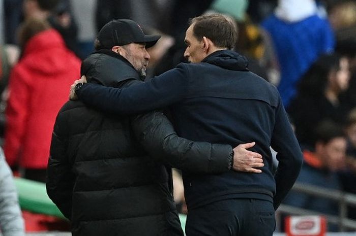 Juergen Klopp (kiri) dan Thomas Tuchel saling rangkul dalam duel final Piala Liga Inggris antara Chelsea vs Liverpool di Wembley, London (27/2/2022).