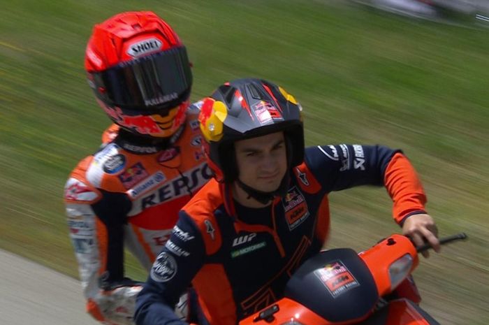 Dani Pedrosa (kanan) mengantarkan mantan rekan setimnya di Repsol Honda, Marc Marquez (kiri), kembali ke paddock pada latihan bebas kedua MotoGP Spanyol 2022 di Sirkuit Jerez, Spanyol, 29 April 2022.