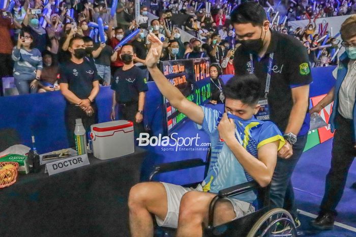 Pebulu tangkis ganda putra Indonesia, Yeremia Erich Yoche Yacob Rambitan, melambaikan tangan kepada penonton sembari menahan kesedihannya karena mengalami cedera saat bertanding pada perempat final Indonesia Open 2022 di Istora Gelora Bung Karno, Senayan, Jakarta, 17 Juni 2022.