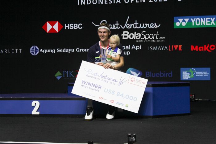 Pebulu tangkis tunggal putra Denmark, Viktor Axelsen yang mengajak anaknya berfoto setelah menjuarai Indonesia Open 2022 di Istora Senayan, Jakarta, pada Minggu (19/6/2022).