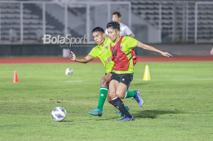 Dua pemain timnas U-19 Indonesia, Razza Fachrezi (kiri) dan Ferdiansyah Cecep Surya (kanan) sedang berebut bola di Stadion Madya, Senayan, Jakarta, 21 Juni 2022.