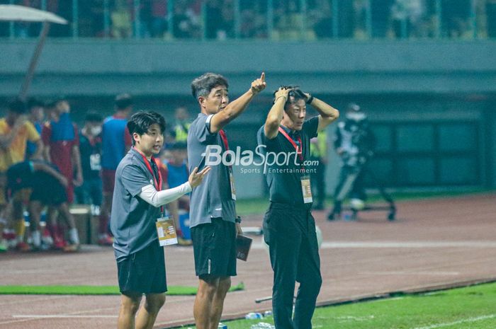 Pelatih timnas U-19 Indonesia, Shin Tae-yong (kanan), nampak sedang serius mengamati dan memberikan intruksi kepada para pemainnya dan ditemani sang asisten yakni Jeong Seok-seo (kiri) dan Kim Bong-soo (tengah) di Stadion Patriot Candrabhaga, Bekasi, Jawa Barat, 2 Juli 2022.