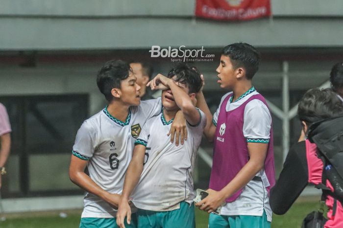 Dua pemain timnas U-19 Indonesia, Frezy Al Hudaifi (kiri) dan Razzaa Fachrezi Aziz (kanan), sedang menenangkan rekannya yang menangis bernama Zanadin Fariz (tengah) pasca gagal lolos ke semifinal Piala AFF U-19 2022.