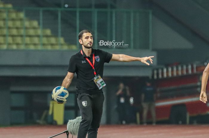 Pelatih timnas U-19 Thailand, Salvador Valero Garcia, sedang memegangi bola sembari memantau para pemainnya bertanding di Stadion Patriot Candrabhaga, Bekasi, Jawa Barat, 13 Juli 2022.