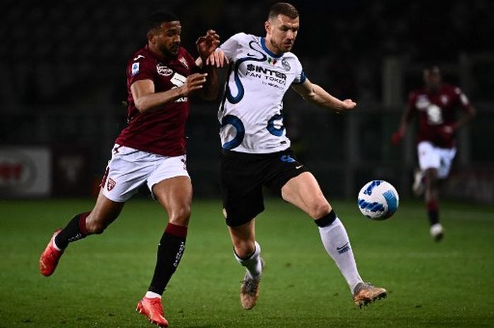 Gleison Bremer (kiri) berduel dengan Edin Dzeko dalam laga Liga Italia antara Torino vs Inter Milan di Stadio Olimpico di Torino (13/3/2022).