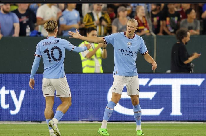 Erling Haaland bersalaman dengan Jack Grealish, pemberi assist dalam laga Manchester City kontra Bayern Muenchen.