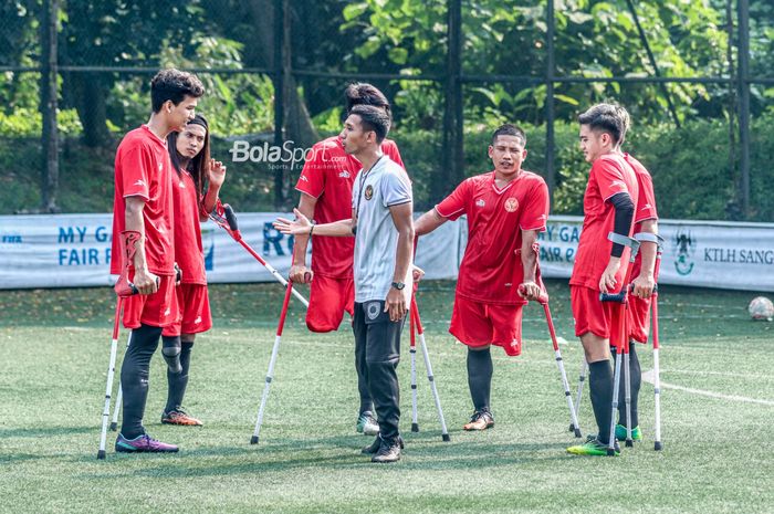 Pelatih timnas amputasi Indonesia atau Garuda INAF, Bayu Guntoro (jersey putih), sedang memberikan intruksi ke para pemainnya saat latihan di Lapangan Serena Hills, Karang Tengah, Jakarta Selaran 27 Juli 2022.