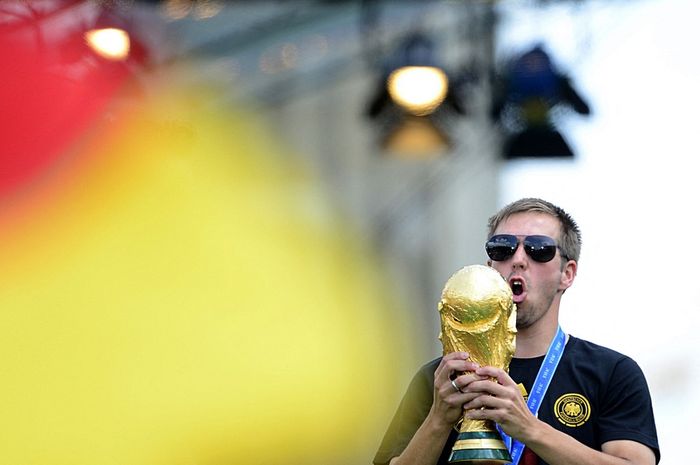 Philipp Lahm berpose dengan trofi Piala Dunia 2014 di Brandeburg Gate, Berlin.