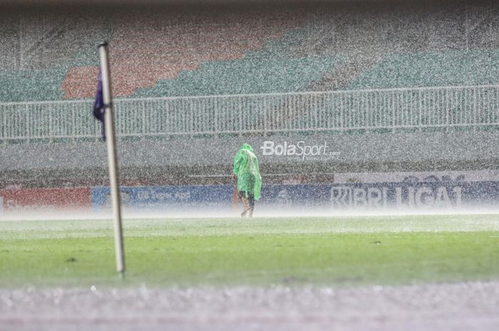 Petugas nampak sedang berupaya agar air tidak menggenang pada rumput dalam laga pekan ketiga Liga 1 2022 antara RANS Nusantara FC versus PSM Makassar di Stadion Pakansari, Bogor, Jawa Barat, 15 Agustus 2022.