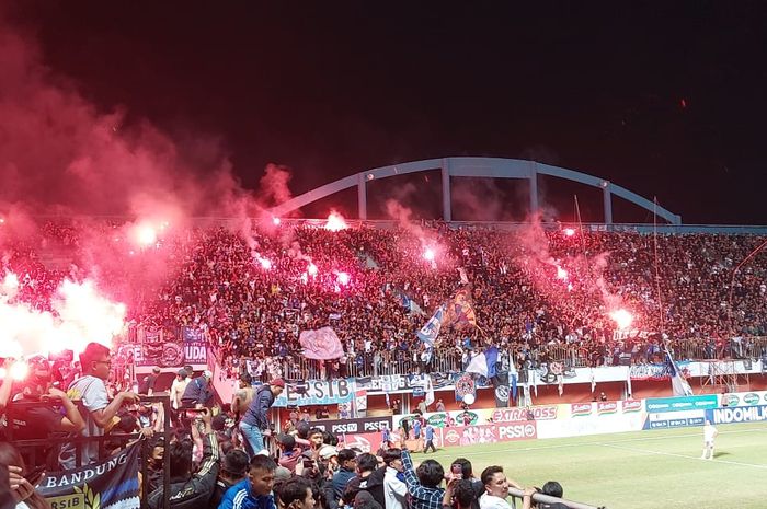 Suporter Persib Bandung menyalakan flare seusai laga melawan PSS Sleman di Stadion Maguwoharjo, Sleman, Jumat (19/8/2022).