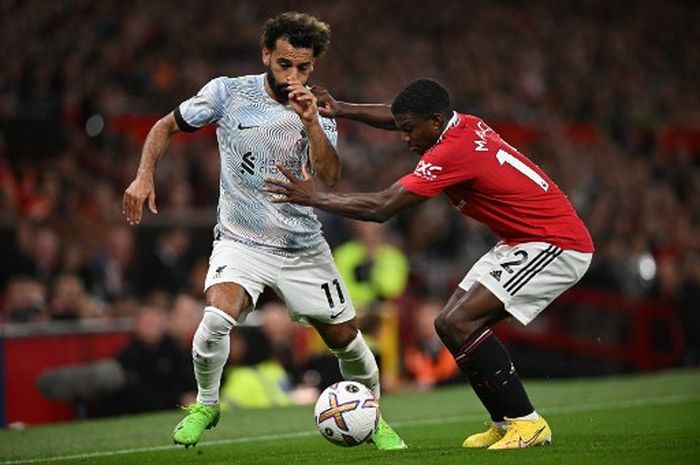 Mohamed Salah (kiri) dikawal ketat Tyrell Malacia dalam duel Manchester United vs Liverpool pada lanjutan Liga Inggris di Old Trafford (22/8/2022).