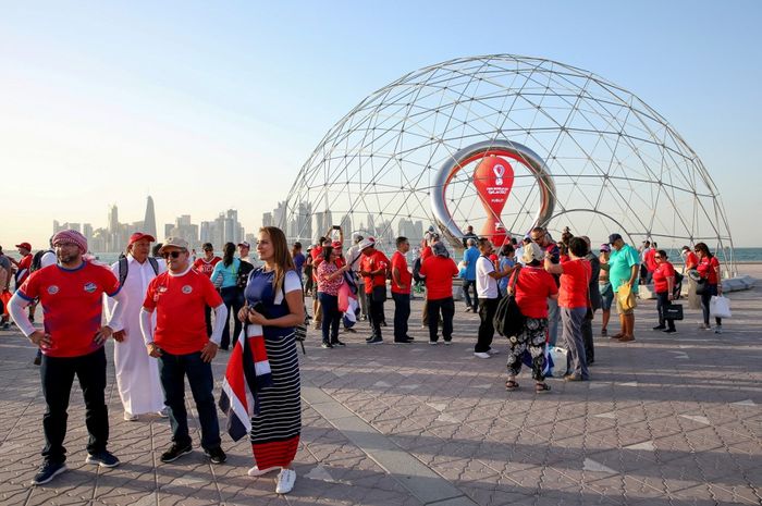 Suporter sepak bola berkumpul di monumen jam hitung mundur Piala Dunia 2022 di Doha, Qatar (16/6/2022).