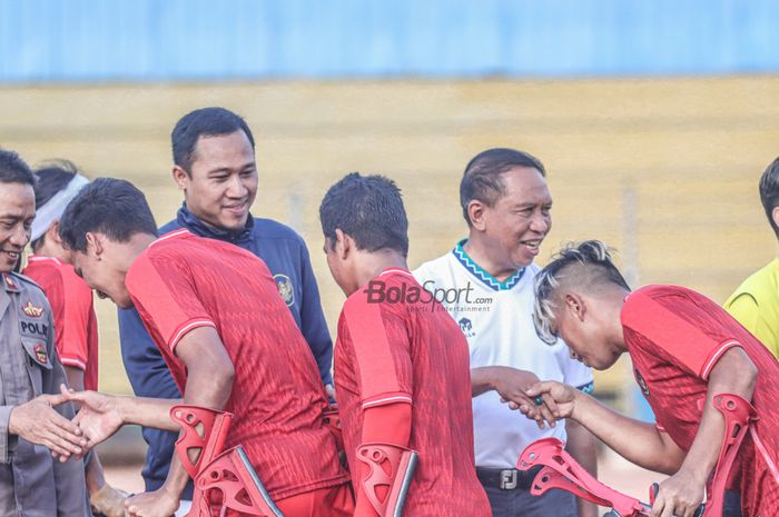 Ketua PSAI (Ketua Perkumpulan Sepak Bola Amputasi Indonesia), Yudhi Yahya (kiri) dan Menteri Pemuda dan Olahraga Republik Indonesia, Zainudin Amali (kanan), sedang menyapa para pemain di Stadion Soemantri Brodjonegoro, Kuningan, Jakarta, 3 September 2022.