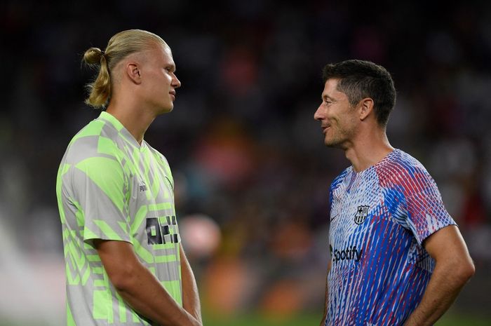 Erling Haaland (kiri) berbicara dengan Robert Lewandowski dalam duel Barcelona vs Manchester City di Camp Nou (24/8/2022).