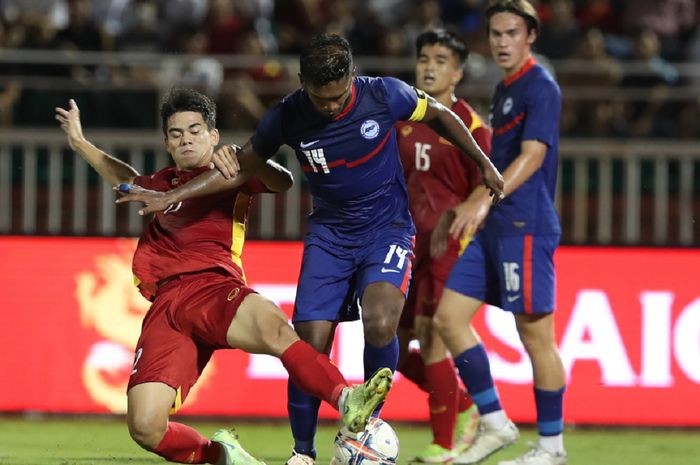 Pemain muda Timnas Vietnam Khuat Van Khang (kiri) merepotkan kapten Singapura Hariss Harun dalam FIFA Matchday di Stadion Thong Nhat, Ho Chi Minh City, 22 September 2022.