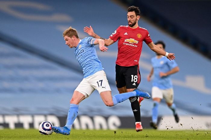 Kevin De Bruyne (kiri) berebut bola dengan Bruno Fernandes dalam partai Liga Inggris Manchester City vs Manchester United di Etihad (7/3/2021).