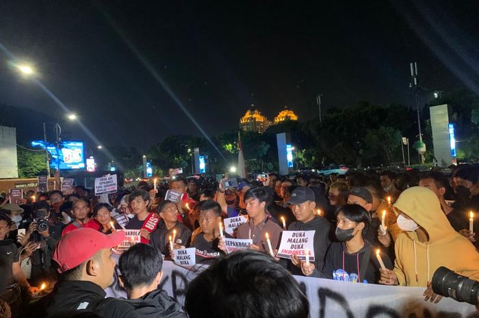 Aksi lilin digerakkan kelompok suporter di Pintu 1 Kawasan Stadion Gelora Bung Karno (SUGBK) Senayan, Jakarta Pusat, Minggu (2/10/2022) malam.