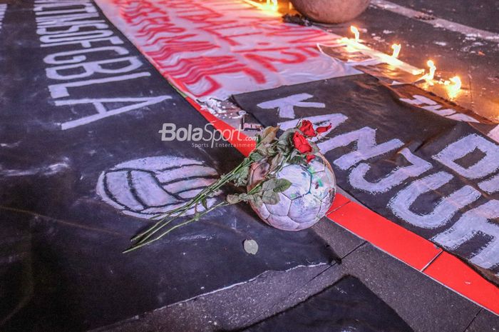 Aksi suporter Bobotoh menaruh bunga di atas bola sebagai wujud duka atas korban jiwa kerusuhan setelah laga Arema FC versus Persebaya Surabaya.