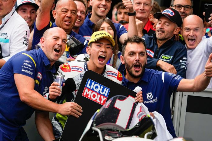 Pembalap Sterilgarda Husqvarna Max Racing, Ayumu Sasaki, merayakan kemenangan pada Moto3 Austria di Red Bull Ring, Austria, 21 Agustus 2022. Tampak pendiri tim, Max Biaggi (memakai topi hitam) ikut bergabung di parc ferme.