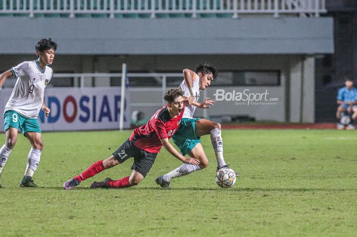 Bek timnas U-17 Indonesia, Sulthan Zaky Pramana (kanan), sedang menguasai bola dan berusaha direbut pilar timnas U-17 Palestina bernama Ahmed Sulaiman (tengah) dalam laga Kualifikasi Piala Asia U-17 2022 di Stadion Pakansari, Bogor, Jawa Barat , 7 Oktober 2022.