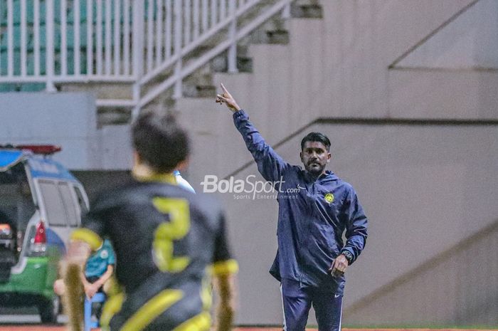 Pelatih timnas U-17 Malaysia, Osmera Bin Omaro (kanan), tampak sedang memberikan intruksi kepada para pemainnya saat bertanding dalam laga Kualifikasi Piala Asia U-17 2023 di Stadion Pakansari, Bogor, Jawa Barat, 9 Oktober 2022.