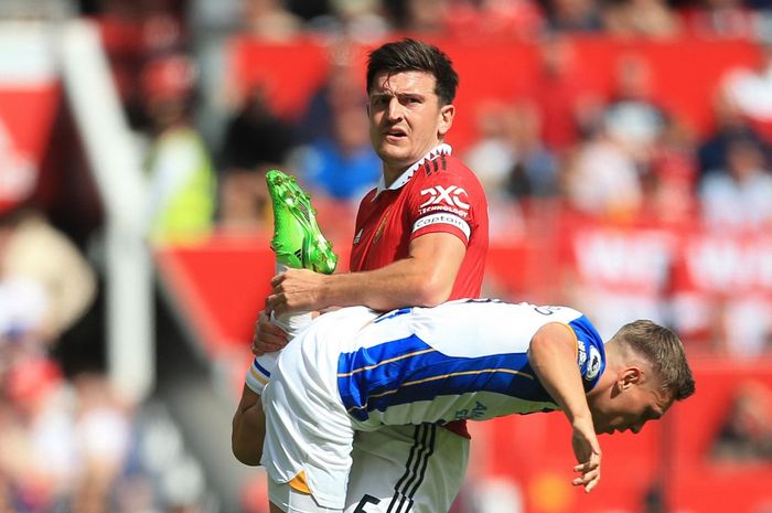 Aksi Harry Maguire mencegah pergerakan Leandro Trossard dalam laga Liga Inggris Manchester United vs Brighton di Old Trafford (7/8/2022).