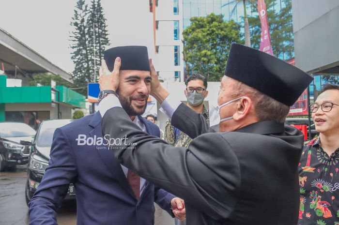 Ketua Umum PSSI, Mochamad Iriawan (kanan), tampak sedang memasangkan peci ke Jordi Amat (kiri) di Kantor Kementerian Hukum dan HAM, Cawang, Jakarta, 17 November 2022.