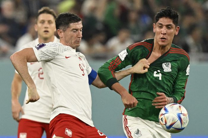 Penyerang Polandia, Robert Lewandowski, kiri, berebut bola dengan pemain Meksiko, Edson Alvarez, pada matchday 1 Grup C Piala Dunia 2022 di Stadion 974, Doha, Qatar, Selasa (22/11/2022)