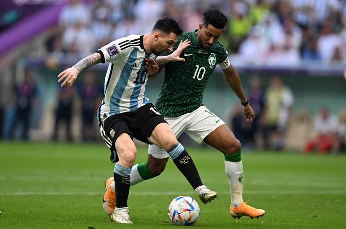 Lionel Messi (kiri) berduel dengan Salem Al-Dawsari dalam partai Piala Dunia 2022 antara timnas Argentina vs timnas Arab Saudi di Stadion Lusail, Qatar (22/11/2022).