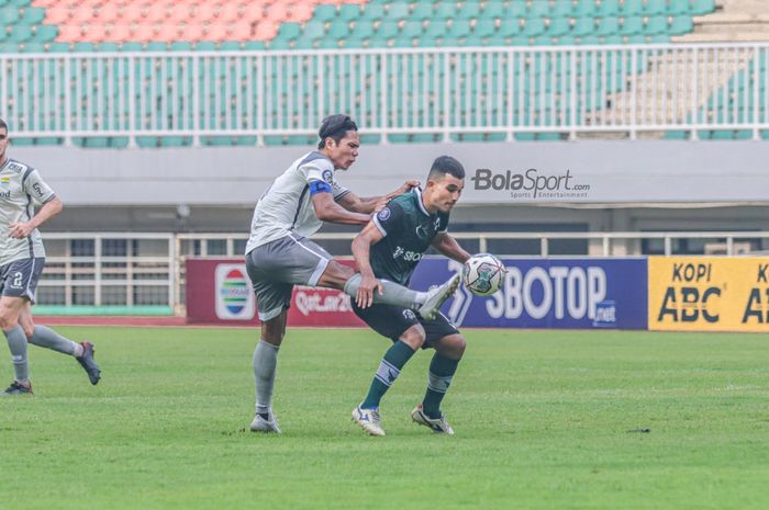 Bek Persib Bandung, Achmad Jufriyanto (kiri), tampak sedang berusaha memghalau bola yang dikuasai striker Persikabo 1973 bernama Gustavo Tocantins (kanan) dalam laga uji coba di Stadion Pakansari, Bogor, Jawa Barat, 27 November 2022.