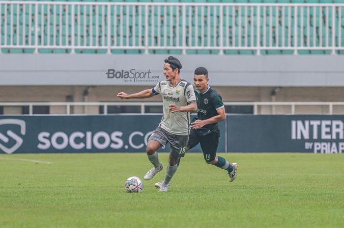 Bek Persib Bandung, Achmad Jufriyanto (kiri), sedang menguasai bola dan dibayangi striker Persikabo 1973 bernama Gustavo Tocantins (kanan) dalam laga uji coba di Stadion Pakansari, Bogor, Jawa Barat, 27 November 2022.