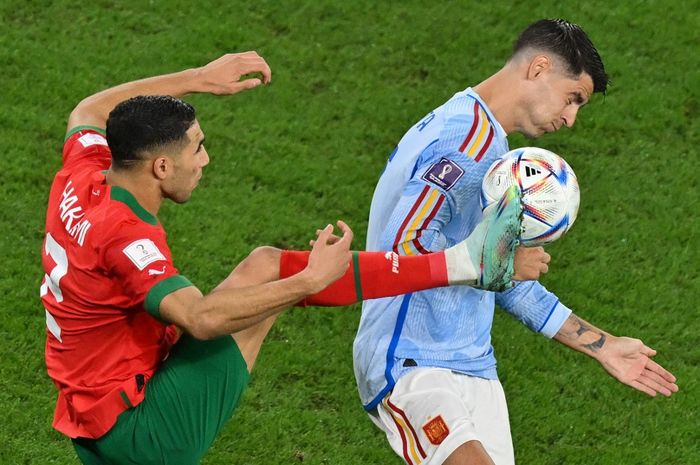 Bek timnas Maroko, Achraf Hakimi  (kiri), berebut bola dengan Alvaro Morata (kanan), pada laga babak 16 besar Piala Dunia 2022 antara timnas Maroko vs timnas Spanyol, Selasa (6/12/2022)