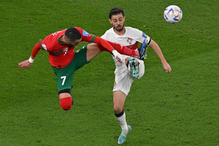 Hakim Ziyech (baju merah) berduel dengan Bernardo Silva (baju putih) dalam laga babak perempat final Piala Dunia 2022 di Al Thumama Stadium, Sabtu (10/12/2022).