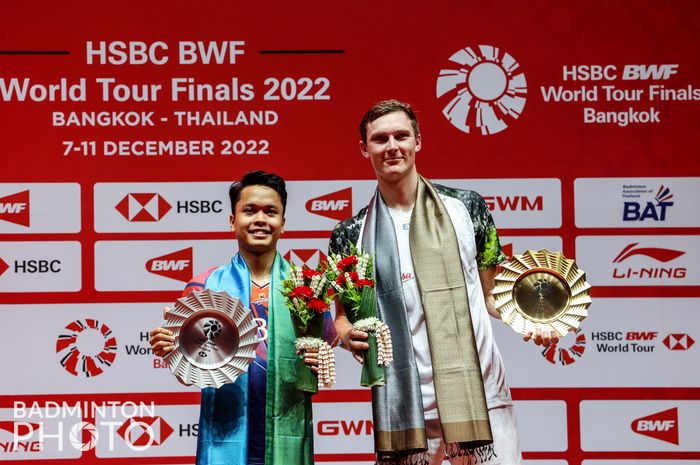 Tunggal putra Indonesia, Anthony Sinisuka Ginting (kiri) dan Viktor Axelsen dari Denmark (kanan) berdiri di podium BWF World Tour Finals 2022, Nimibutr Stadium, Bangkok, Thailand, Minggu (11/12/2022).