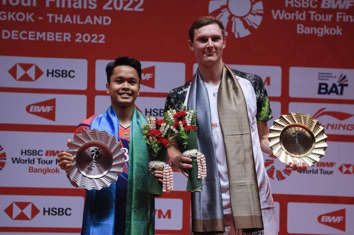 Tunggal putra Indonesia, Anthony Sinisuka Ginting (kiri) dan Viktor Axelsen dari Denmark (kanan) berdiri di podium BWF World Tour Finals 2022, Nimibutr Stadium, Bangkok, Thailand, Minggu (11/12/2022).