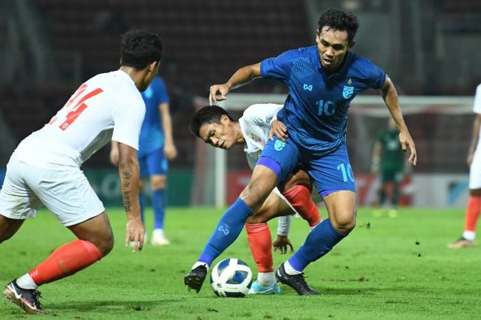 Bomber Timnas Thailand, Teerasil Dangda, berduel dengan pemain Timnas Myanmar.