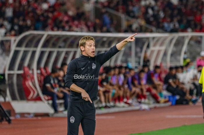 Manajer timnas Kamboja, Keisuke Honda (kiri), tampak sedang memberikan intruksi kepada para pemainnya dalam laga pekan pertama Grup A Piala AFF 2022 di Stadion Gelora Bung Karno, Senayan, Jakarta, 23 Desember 2022.