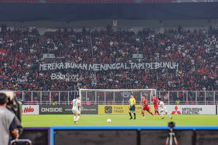 Suporter timnas Indonesia membentangkan spanduk terkait tragedi Kanjuruhan dalam laga pekan pertama Grup A Piala AFF 2022 di Stadion Gelora Bung Karno, Senayan, Jakarta, 23 Desember 2022.