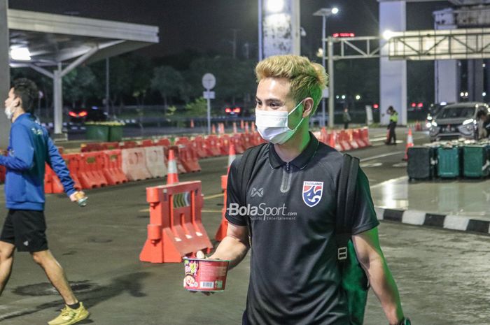 Bek sayap kiri timnas Thailand, Theerathon Bunmathan, tampak sedang memegangi makanan saat tiba di Bandara Soekarno Hatta, Tangerang, Banten, 27 Desember 2022.