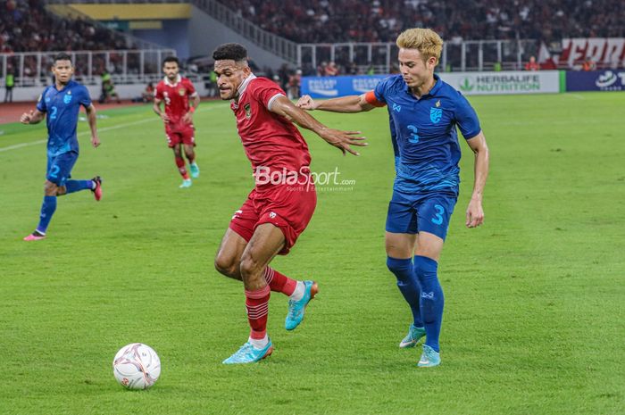 Gelandang timnas Indonesia, Ricky Kambuaya (kiri), sedang menguasai bola dan dibayangi pemain timnas Thailand bernama Theerathon Bunmathan (kanan) dalam laga Piala AFF 2022 di Stadion Utama Gelora Bung Karno, Senayan, Jakarta, 29 Desember 2022.